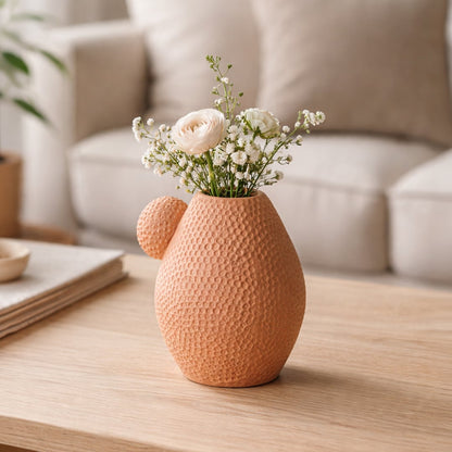 White marble ceramic vase with grey veins placed on living room table with books in soft neutral home decor setting.