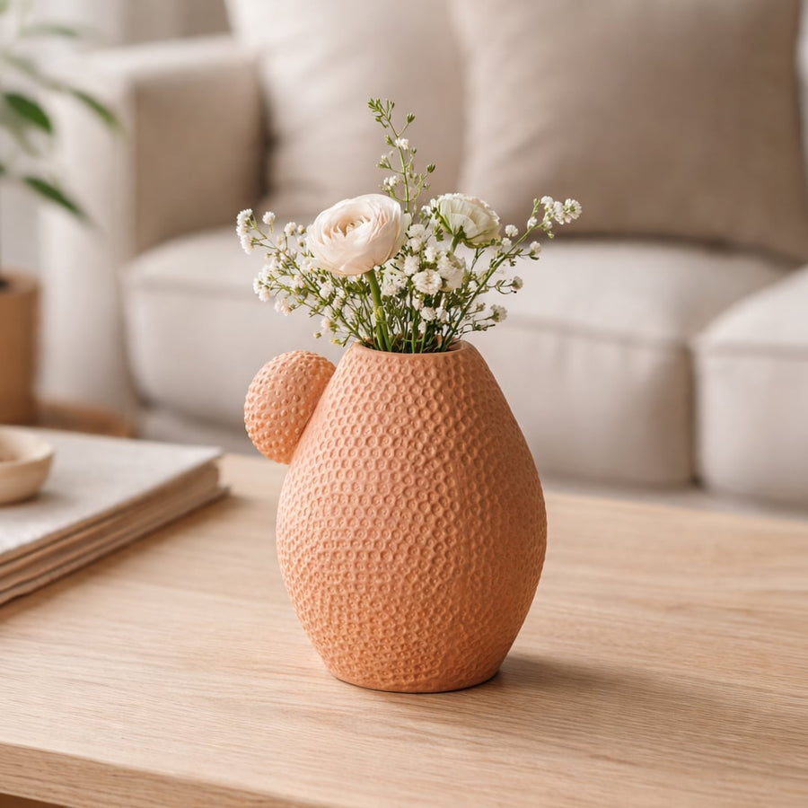 White marble ceramic vase with grey veins placed on living room table with books in soft neutral home decor setting.