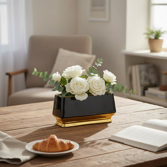 Black and gold metal planter styled on table in modern living room setting for elegant home decor display.