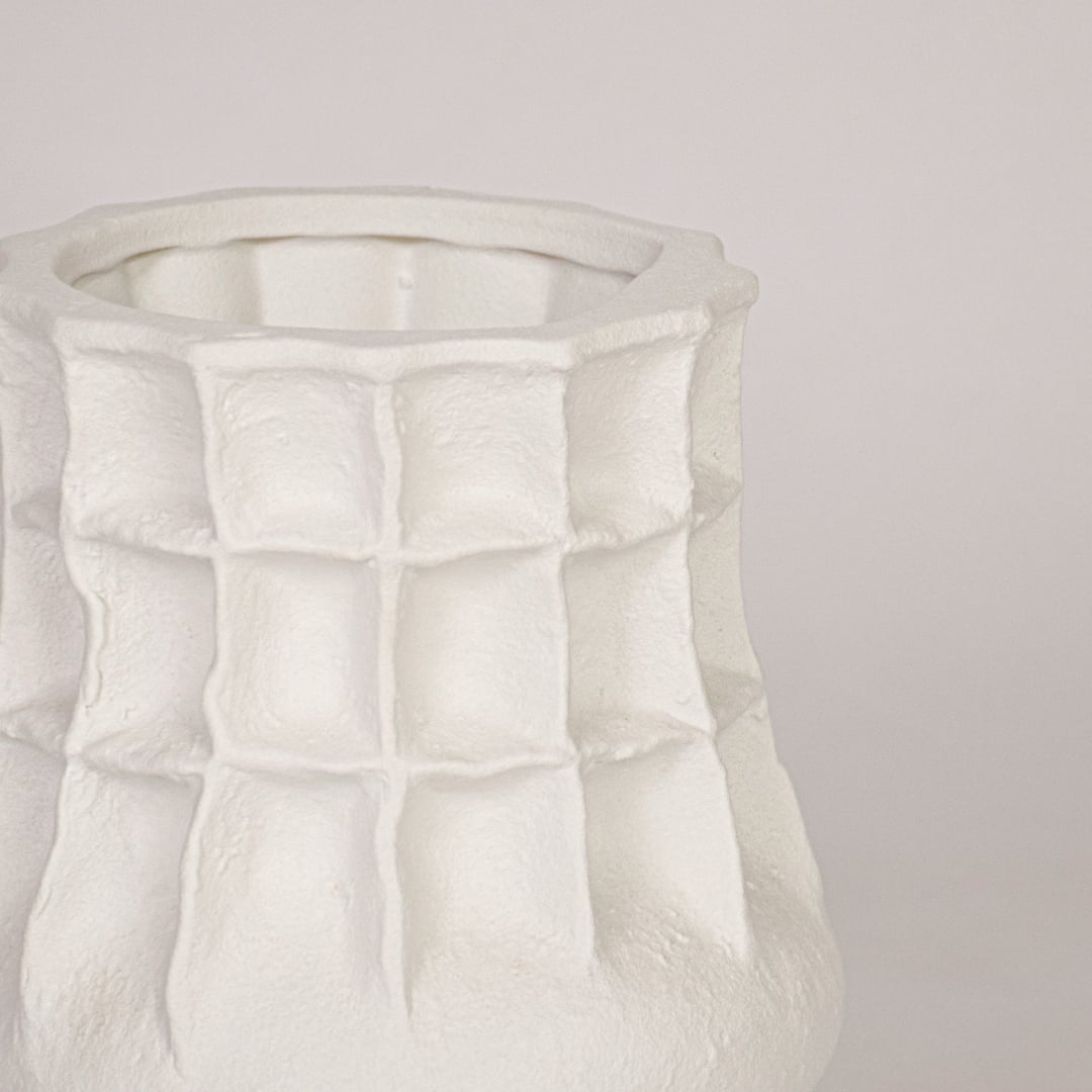 Close view of white ceramic vase showing textured grid design and smooth matte finish for premium decor look.