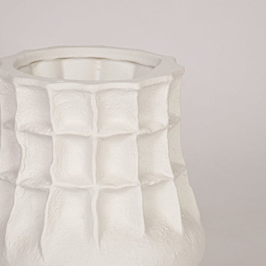 Close view of white ceramic vase showing textured grid design and smooth matte finish for premium decor look.