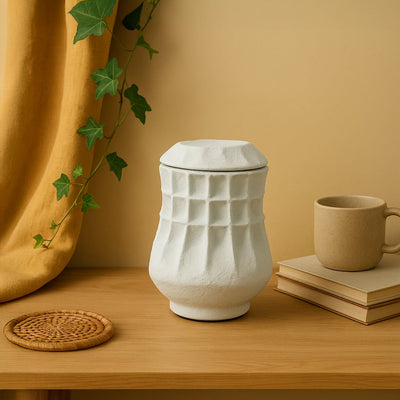 White ceramic decorative vase styled on a wooden table for elegant contemporary home decor and tabletop styling.