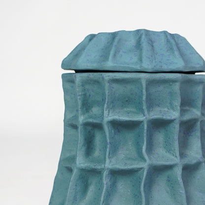 Closeup image of blue ceramic textured planter vase for modern tabletop decor styling with artistic matte finish.