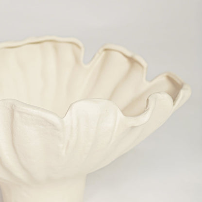 Close view of white ceramic floral bowl featuring soft curved petals and elegant matte finish.