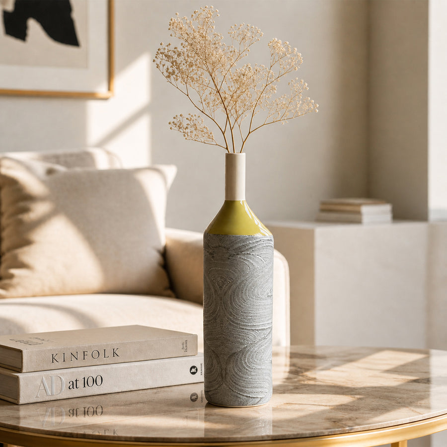 Grey and green ceramic flower vase with dried stems placed on table for stylish modern home decor.
