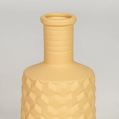 Closeup yellow ceramic geometric textured vase surface detail modern decorative flower vase for living room table shelf decor styling.