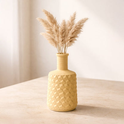 Lifestyle yellow ceramic textured flower vase with dried pampas grass placed on table minimal home decor styling aesthetic interior setup.
