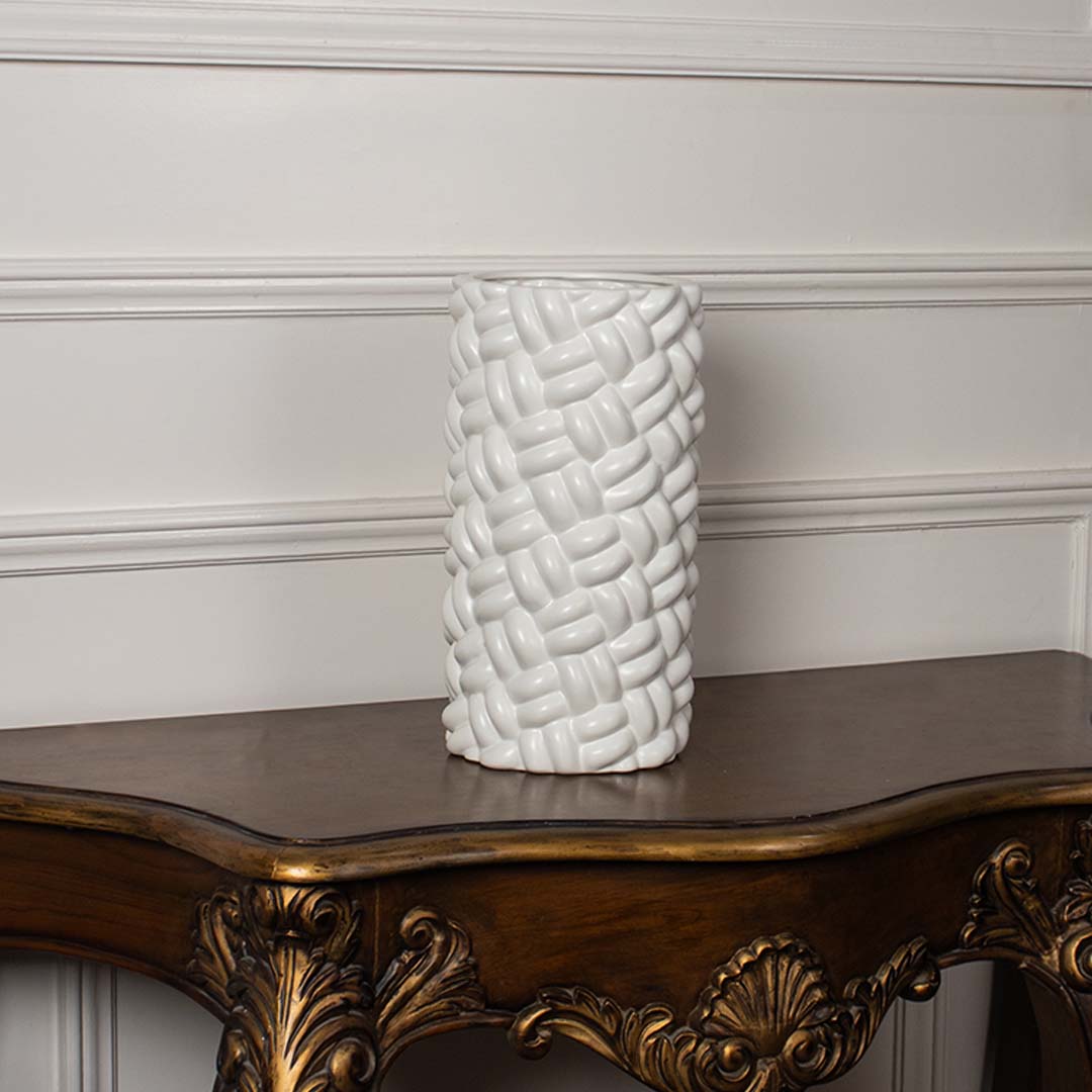 A textured white decorative vase displayed on a plain white background showcasing its woven design and modern cylindrical shape clearly.