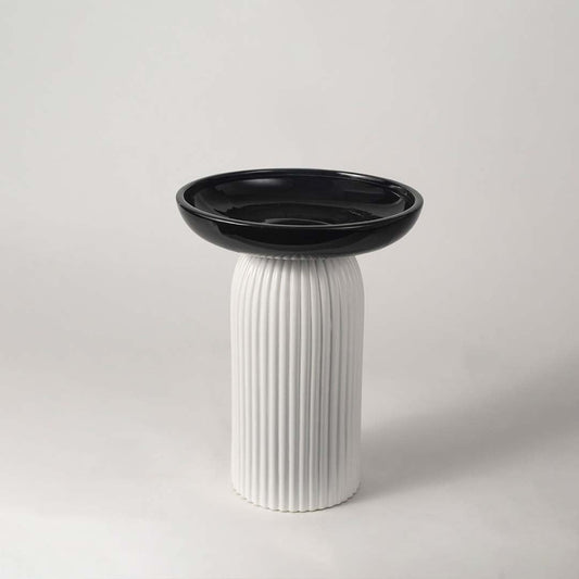 A contemporary pedestal bowl with a glossy black top and ribbed white base presented on a white background for a clean minimal look.
