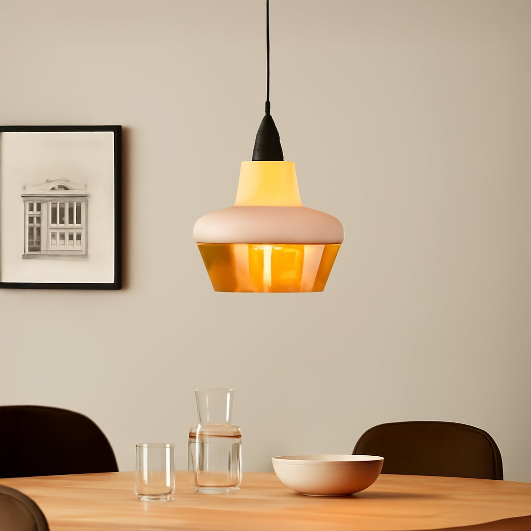Modern pendant light with white and amber glass shade glowing warmly above dining table for stylish home interiors.