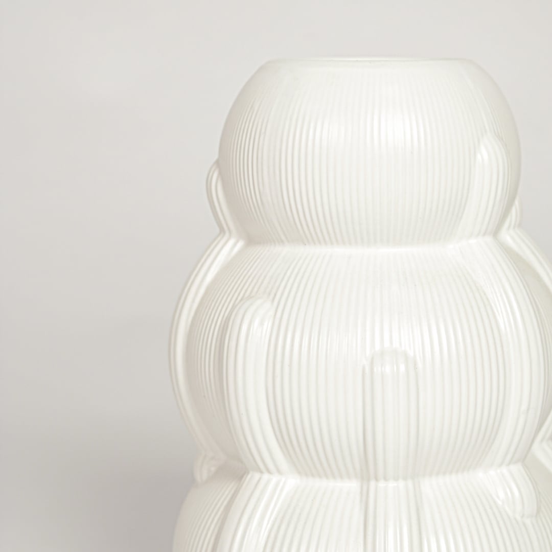 Close view of Samana ribbed white ceramic vase highlighting layered curved form and vertical textured detailing.