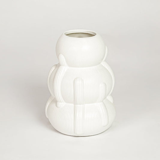 Closeup of glossy white ceramic vase with curved layered form ideal for elegant home decor shelf or side table styling.