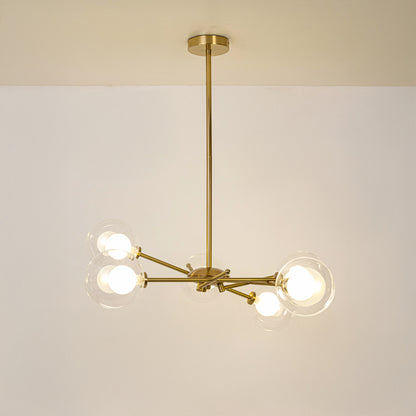 Gold metal chandelier with illuminated clear glass globe shades offering elegant contemporary ceiling lighting indoors.