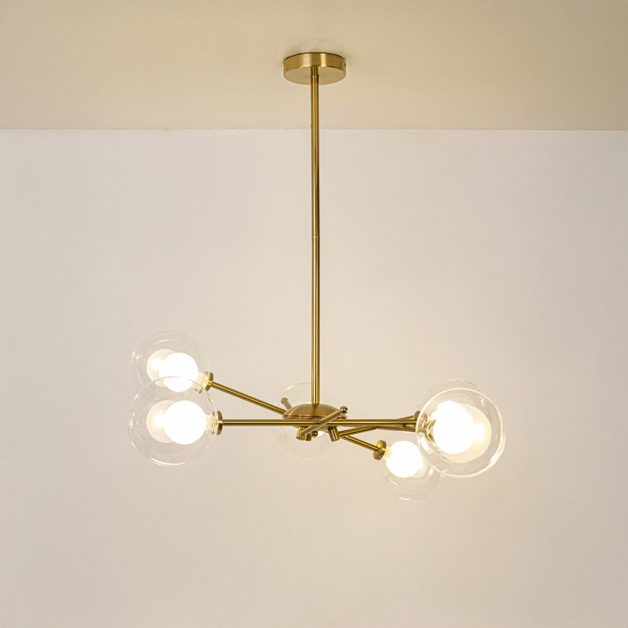 Gold metal chandelier with illuminated clear glass globe shades offering elegant contemporary ceiling lighting indoors.