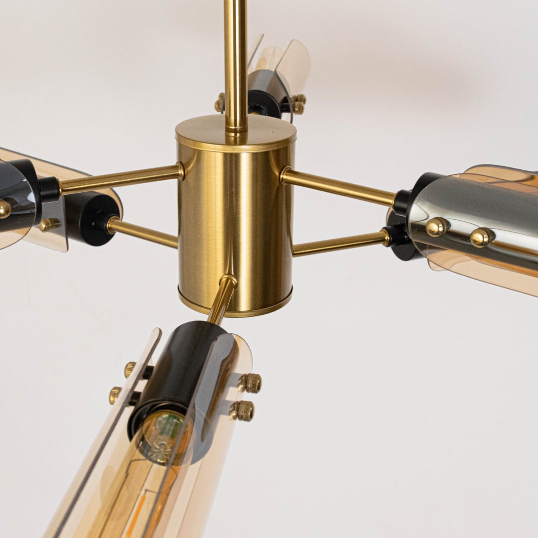 Closeup of black metal chandelier showing smoky glass tube lights with warm glow for luxury contemporary ceiling decor.