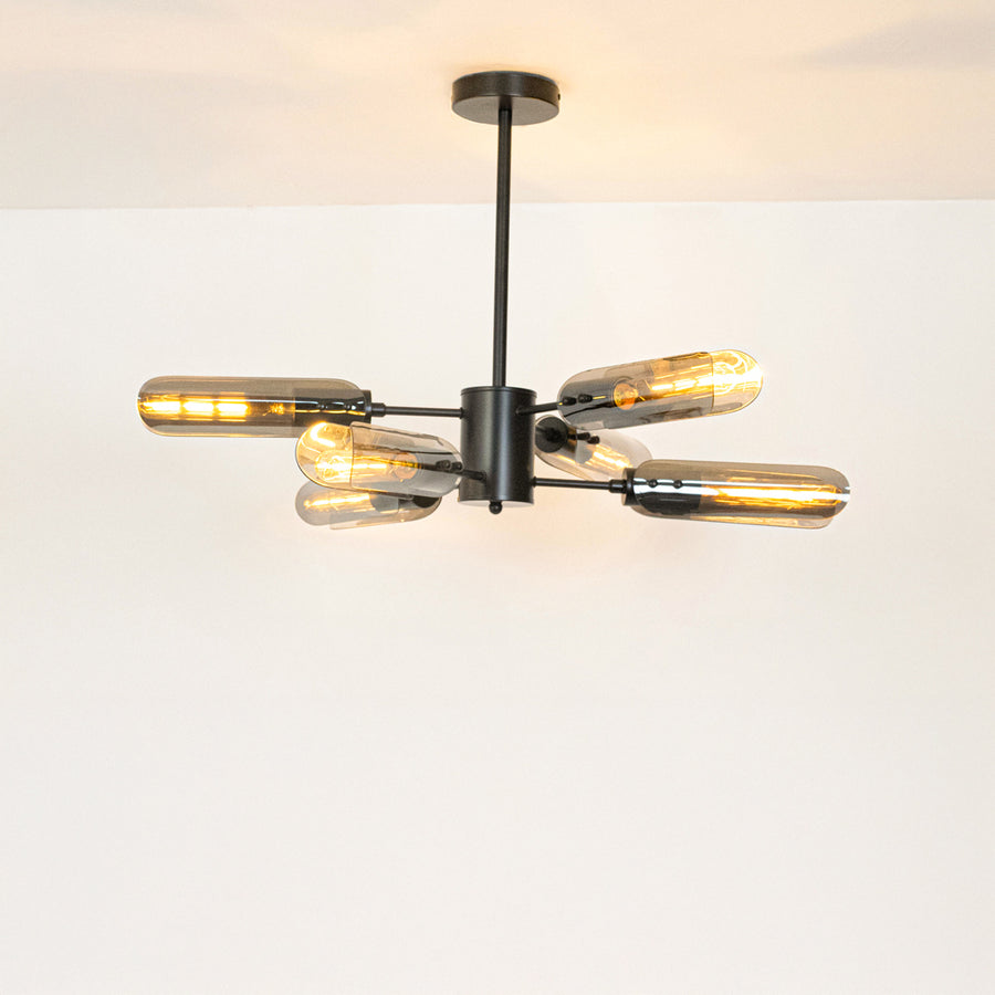 Black metal chandelier with crystal tube shades creating sophisticated ambient lighting for modern interior spaces.