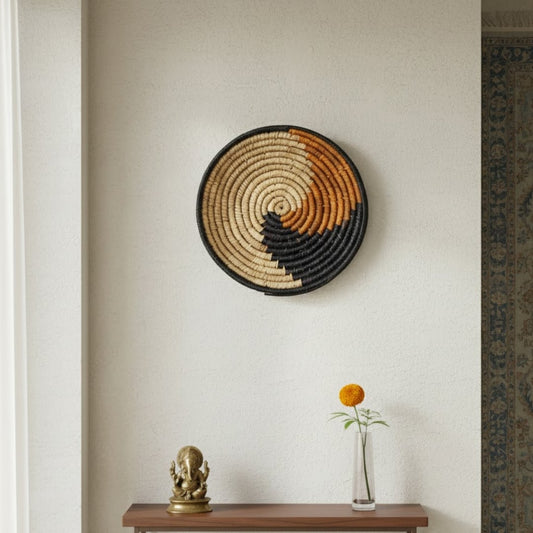 Handwoven round wall basket Decor styled on a neutral indoor wall above a wooden shelf with minimal accents creating a warm ethnic and modern home Decor look.