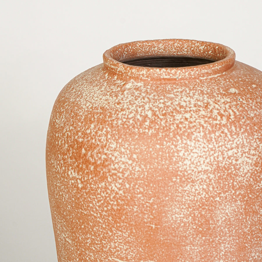 Closeup image of peach ceramic rustic vase for modern tabletop decor styling with artistic textured finish.