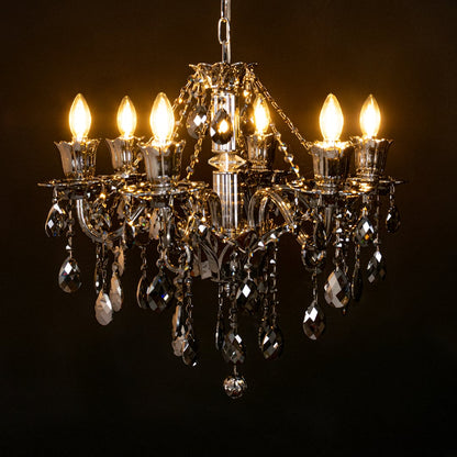 Black crystal chandelier glowing warmly on black background creating a dramatic luxury ceiling statement.