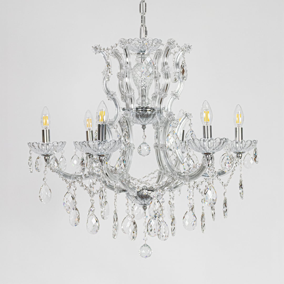 Chrome crystal chandelier with sculpted glass arms and drops shown on white background for elegant home decor inspiration.