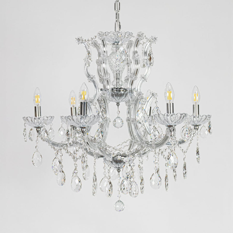 Chrome crystal chandelier with sculpted glass arms and drops shown on white background for elegant home decor inspiration.