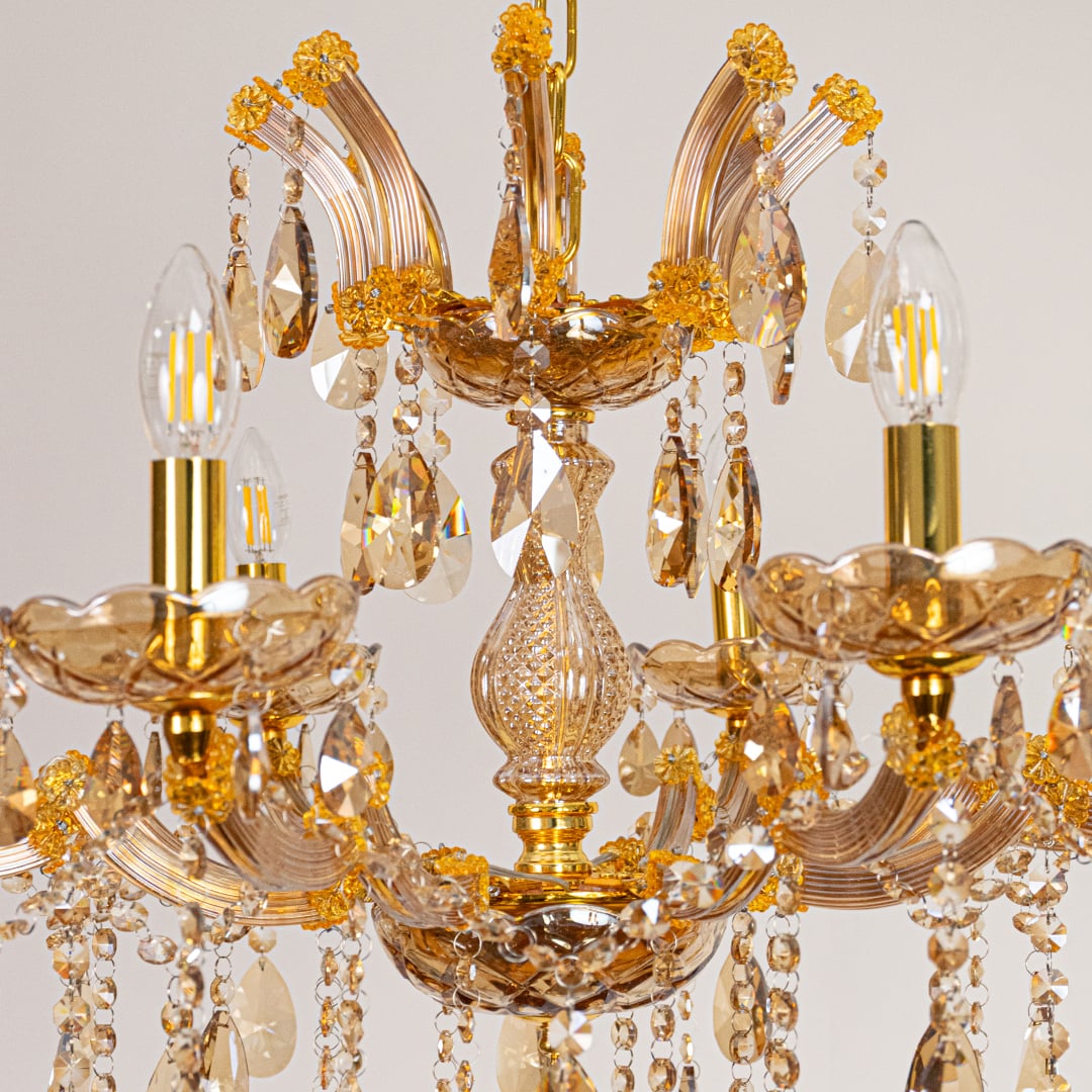 Closeup of gold crystal chandelier arms and hanging drops showing fine detailing for luxurious interior lighting.