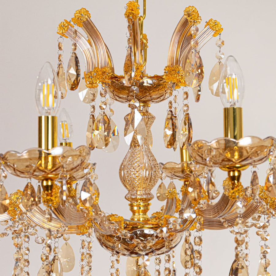 Closeup of gold crystal chandelier arms and hanging drops showing fine detailing for luxurious interior lighting.