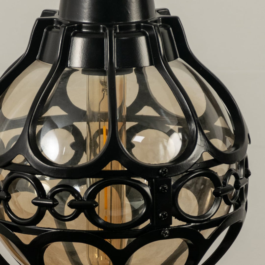 Close up view of the decorative metal rings and inner glass globe of the black spherical cage pendant light fixture.