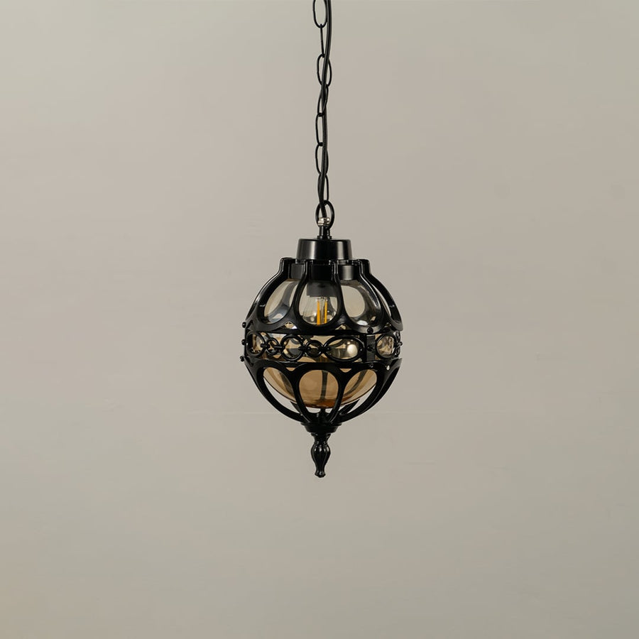 Unlit black metal globe hanging light fixture with decorative circular pattern cage isolated against a plain white background.