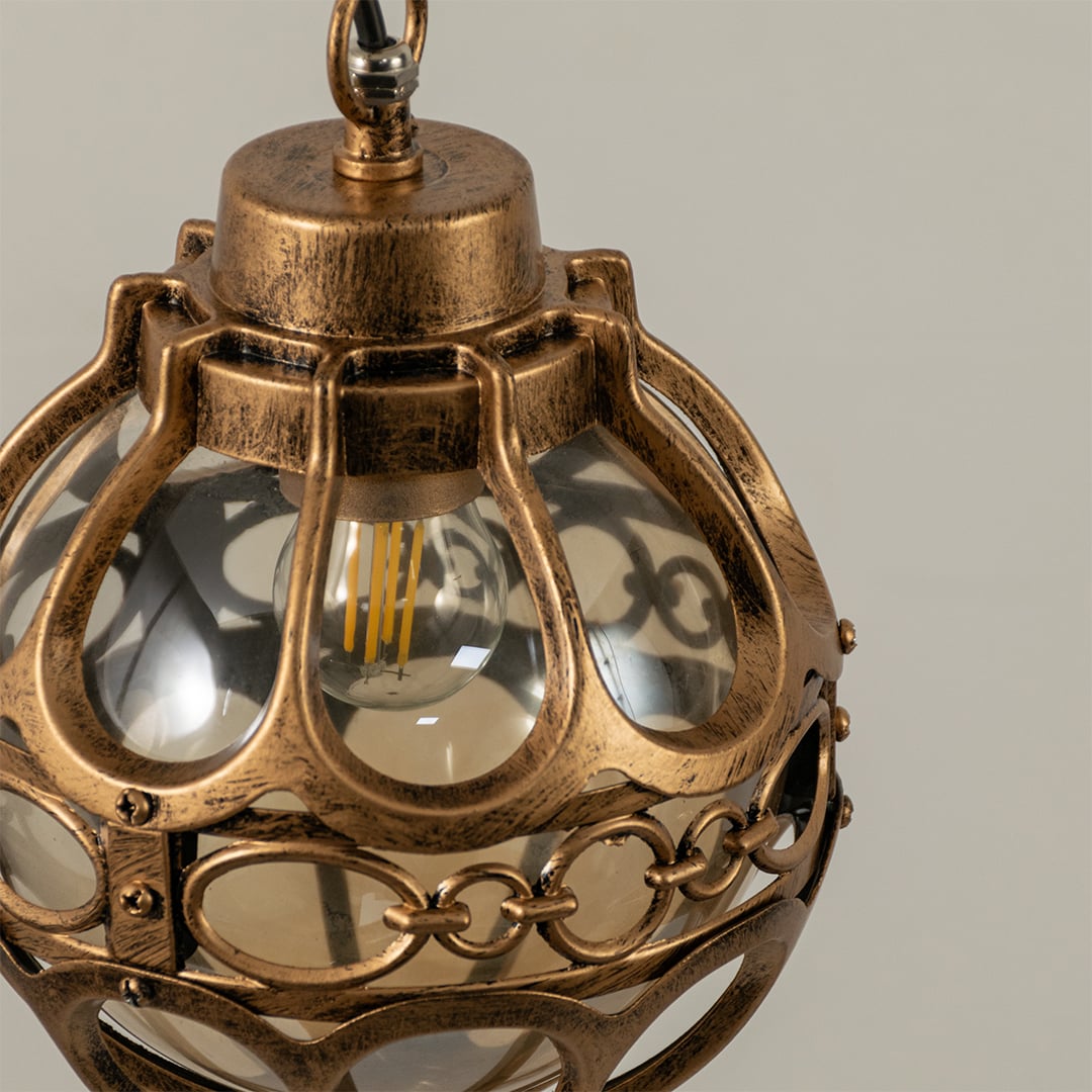 Close up view of the decorative metal rings and inner glass globe of the black spherical cage pendant light fixture.
