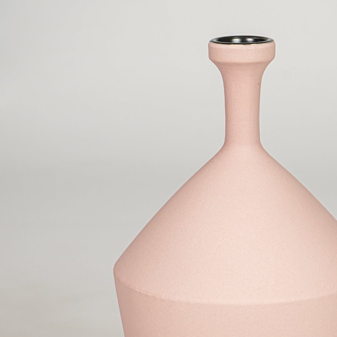 Pink ceramic flower vase closeup modern decorative vase for tabletop shelf console living room decor styling.