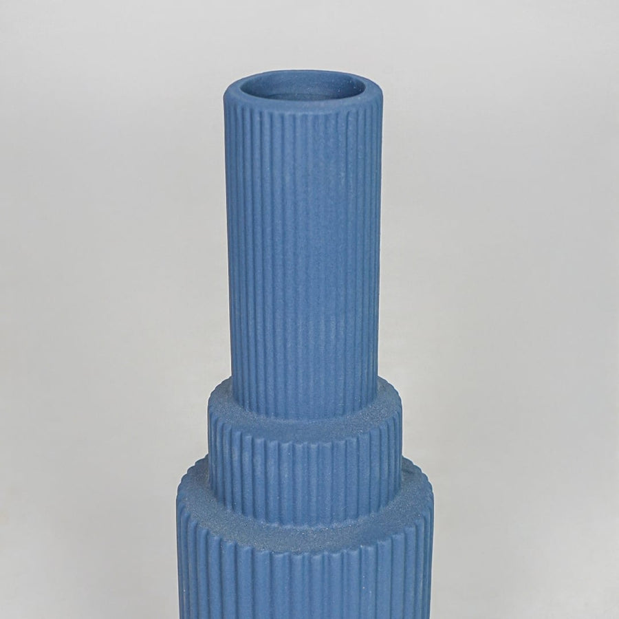 Closeup blue ribbed ceramic vase texture detail modern decorative flower vase for table shelf console decor.