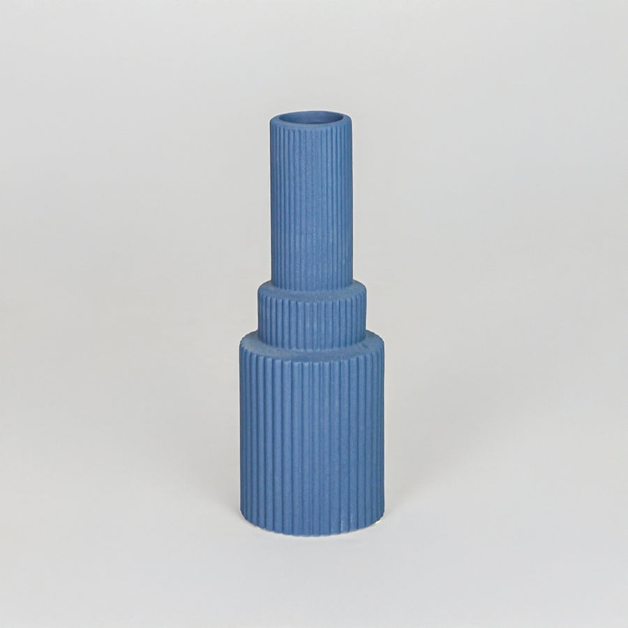 Minimalist blue architectural vase with ribbed texture for modern home decor and clean tabletop shelf styling.