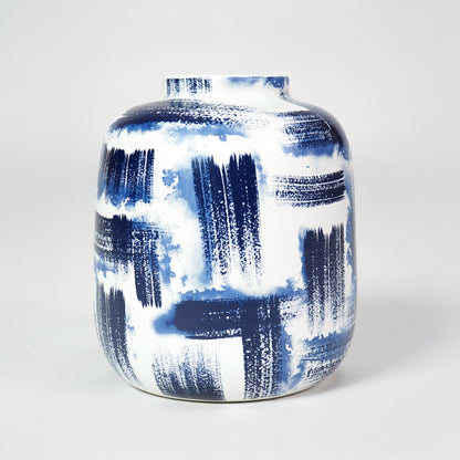 White ceramic rounded vase with bold blue brushstroke pattern for stylish modern home decor and accent display.