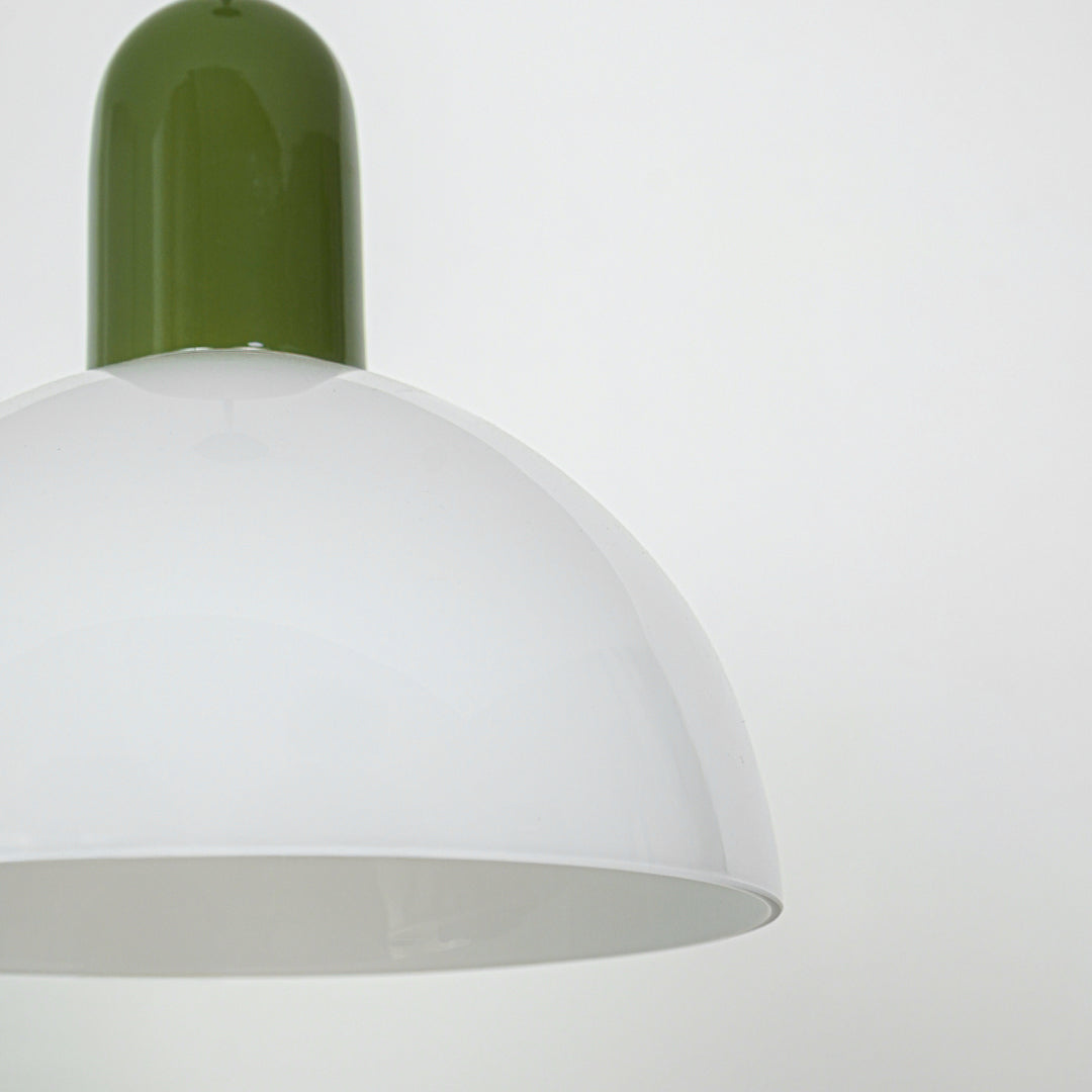 Closeup of pendant light with green metal top and smooth white dome shade showcasing modern design for interior lighting decor.