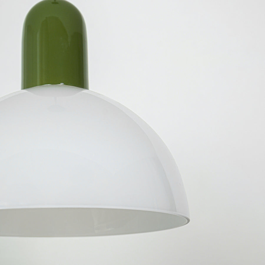 Closeup of pendant light with green metal top and smooth white dome shade showcasing modern design for interior lighting decor.