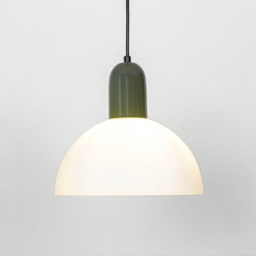 Pendant light with white dome shade and green metal top emitting soft warm glow ideal for kitchen or dining decor placement.