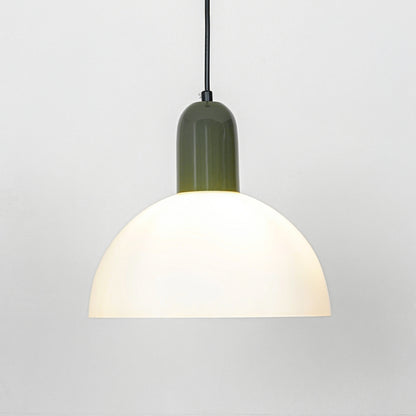 Pendant light with white dome shade and green metal top emitting soft warm glow ideal for kitchen or dining decor placement.