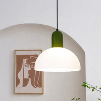 Modern pendant light with white dome shade and green top styled above dining area creating warm ambient lighting in home interior.