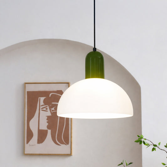 Modern pendant light with white dome shade and green top styled above dining area creating warm ambient lighting in home interior.