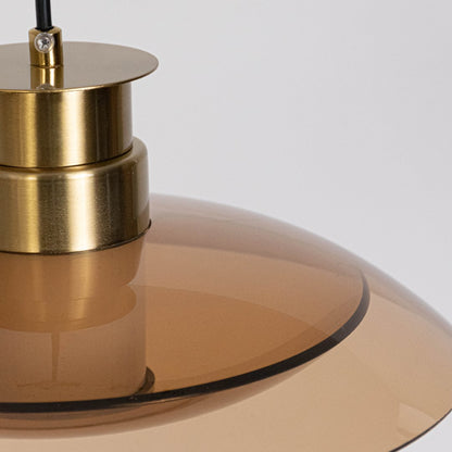 Closeup of gold metal disc pendant light highlighting smooth finish and premium craftsmanship details.