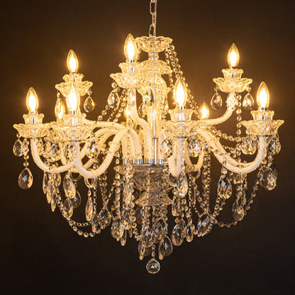 Large clear crystal chandelier glowing warmly on black background creating a dramatic luxury ceiling feature.