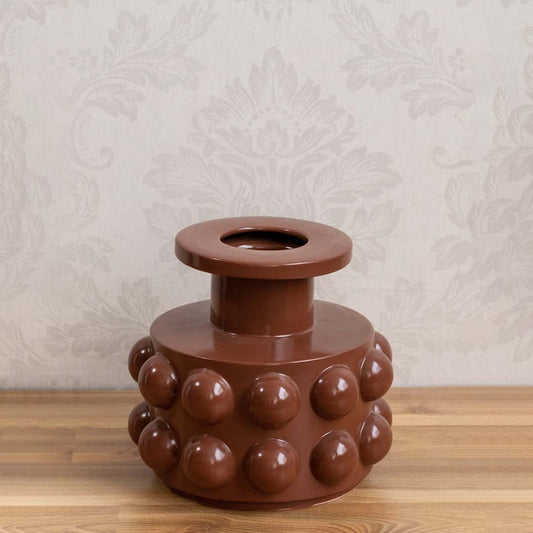 Brown ceramic decorative vase with bubble detailing styled on a wooden table for warm modern home decor displays.