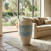 Beige and blue floor vase placed beside sofa for elegant contemporary living room decor styling.