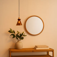 Copper metal pendant light above console table creating warm ambient lighting in a stylish contemporary interior.