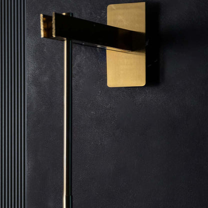 Close-up of a modern wall sconce with amber glass shade and metal frame