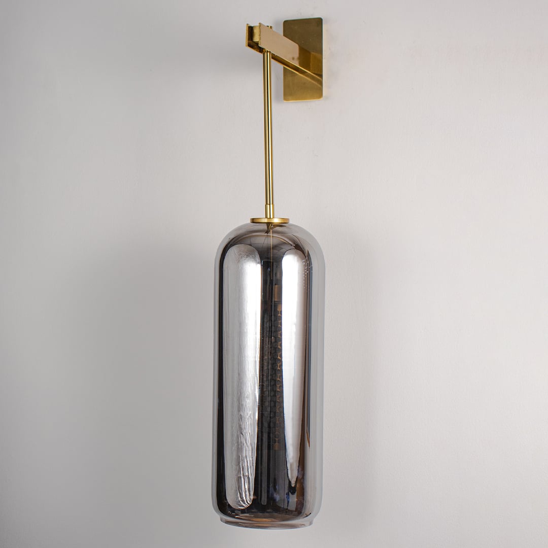 Unlit modern wall sconce featuring sleek gold rod and dark glass cylinder isolated on white background for minimalist home styling.