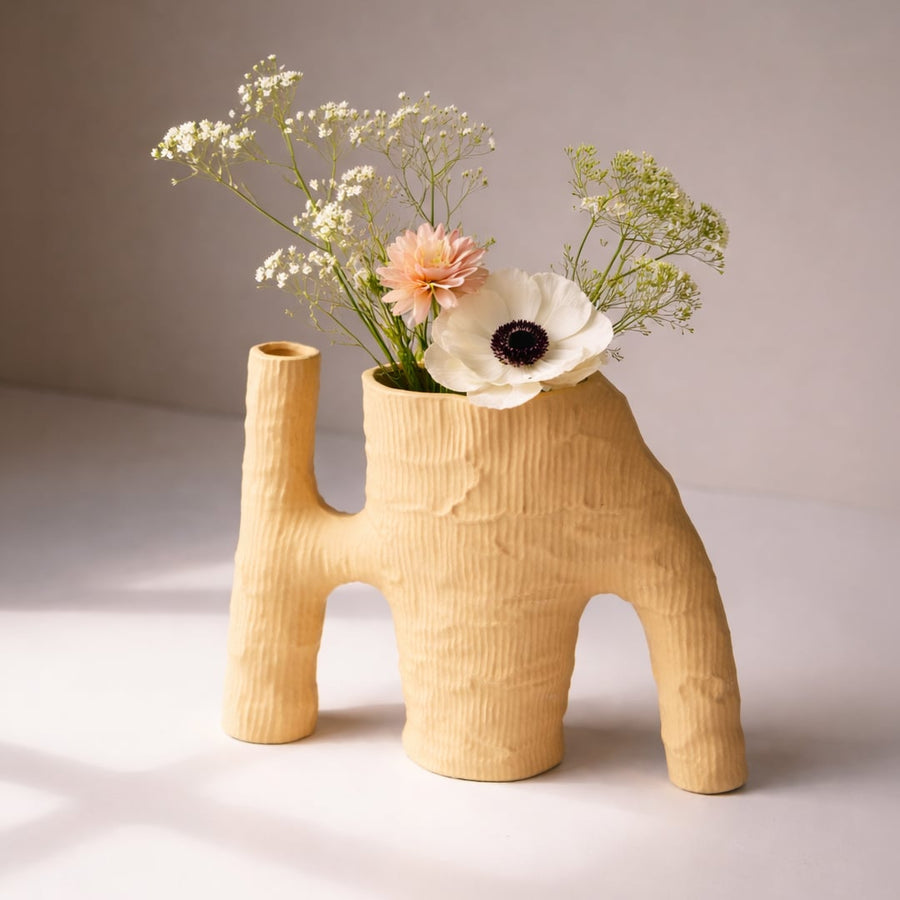 Beige ceramic flower vase with textured finish styled with fresh blooms for elegant modern home decor placement.