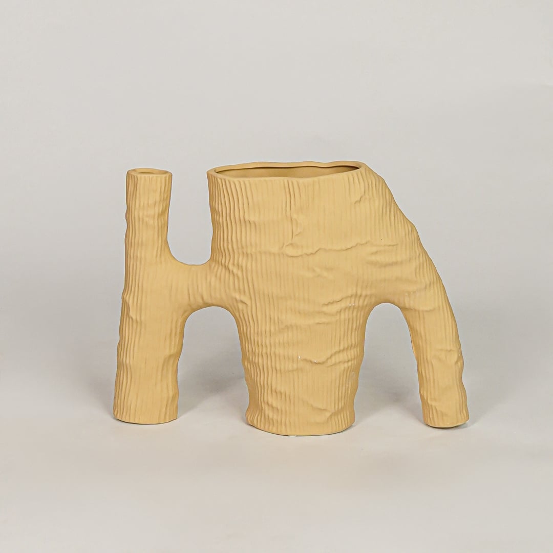 Beige ceramic decorative vase with textured artistic design for modern tabletop shelf and console decor styling.