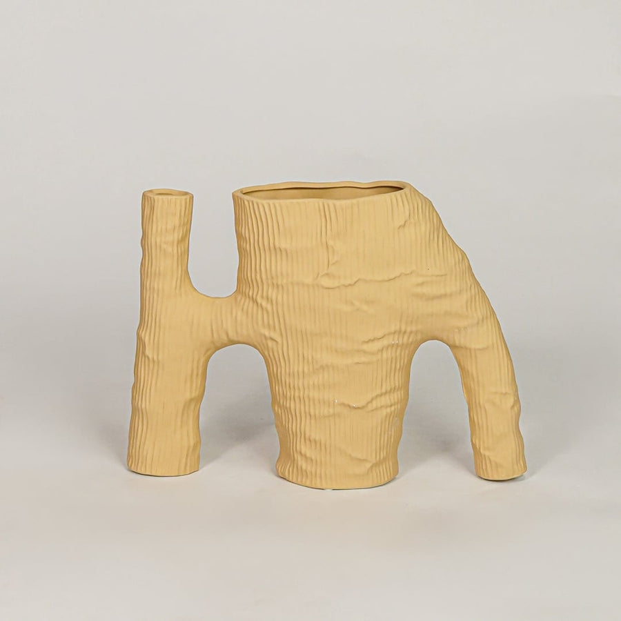 Beige ceramic decorative vase with textured artistic design for modern tabletop shelf and console decor styling.